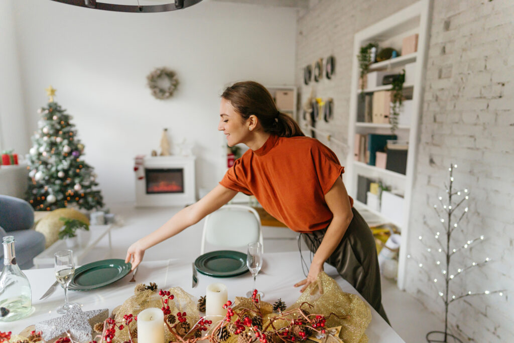 Get Your Home Ready for the Holidays with Professional Cleaning in Plano 1 Photo of a young woman who is hosting a Christmas party having the last preparations on the venue; setting the table and making sure everything's ready.